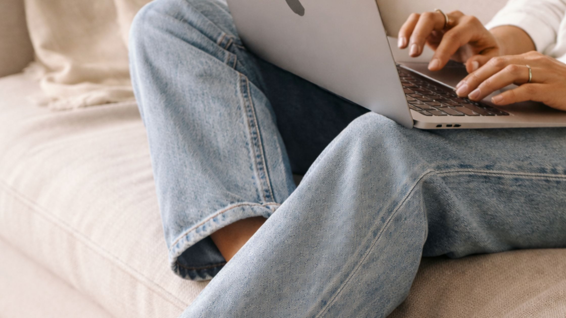 Woman sitting on a couch working on her laptop