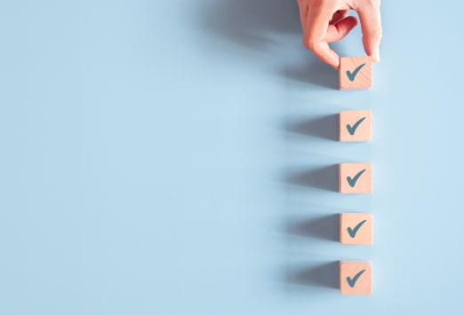 Wooden tick icons being arranged in a straight line