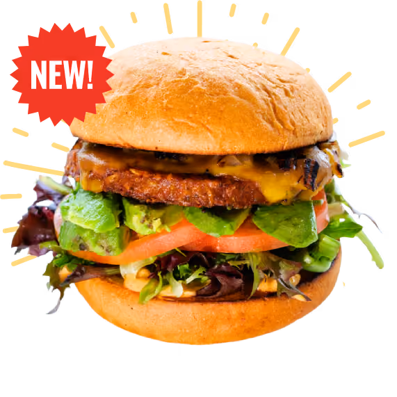 Juicy burger with a grilled patty, melted cheese, avocado, tomato, lettuce, and sauce on a bun. Radiating lines and black background create a vibrant, appetizing look.