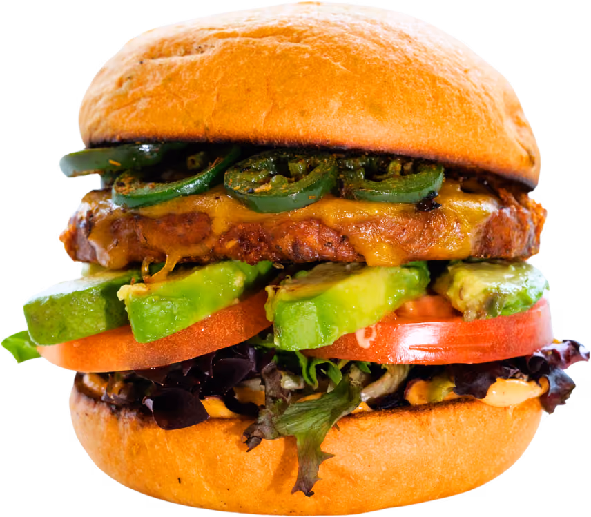 A juicy burger with melted cheese, sliced jalapeños, avocado, tomato, and leafy lettuce in a soft bun. Vibrant, fresh, and appetizing.