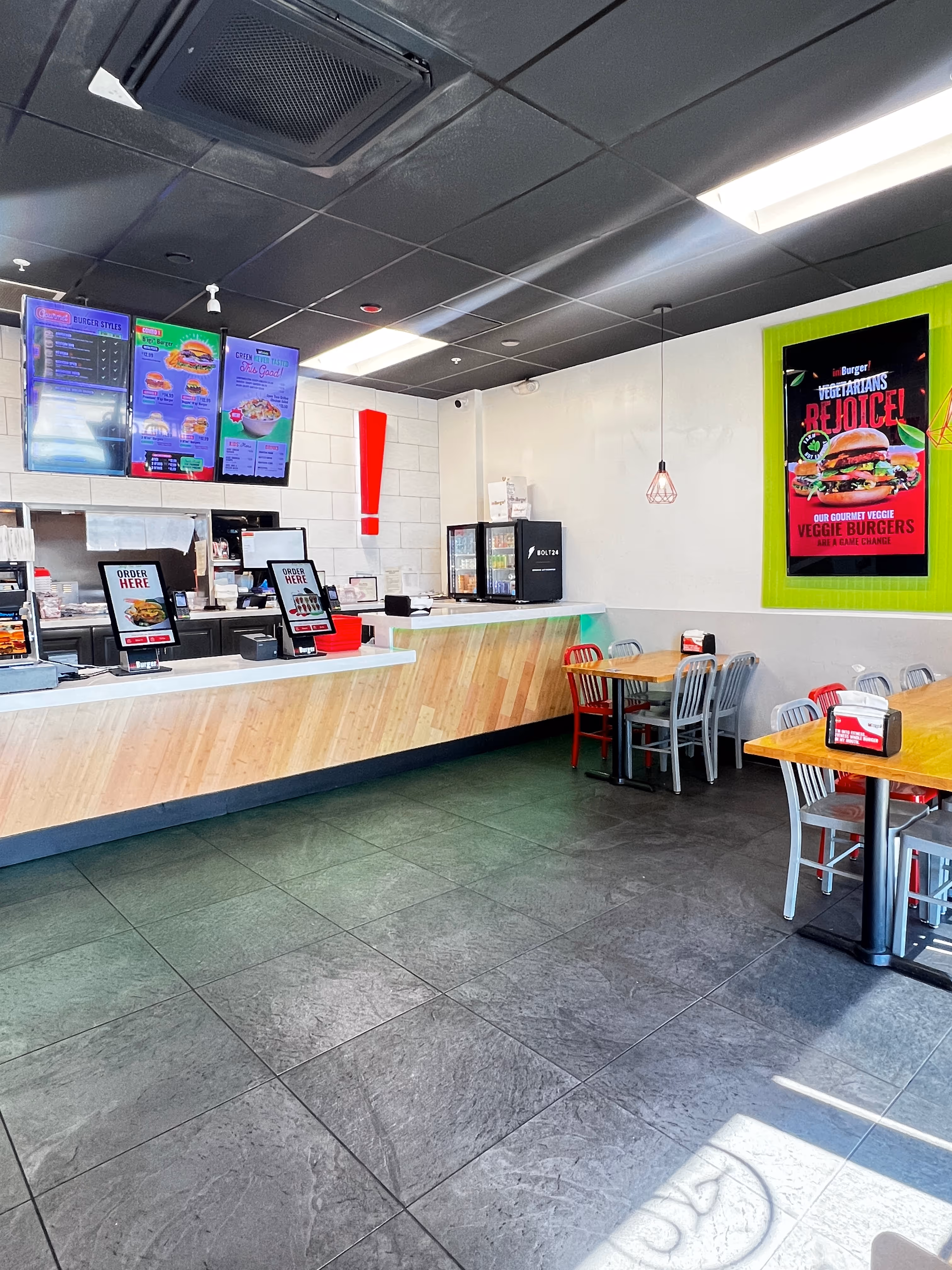 Two closed imBurger takeout boxes with white lids printed with various food-related icons and the red logo on a white surface.
