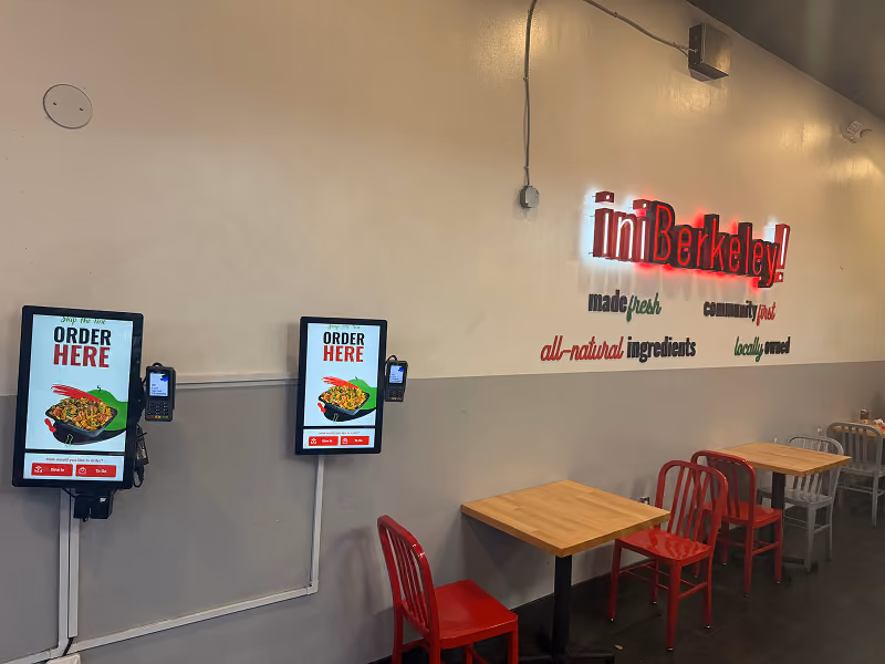 Two closed imBurger takeout boxes with white lids printed with various food-related icons and the red logo on a white surface.