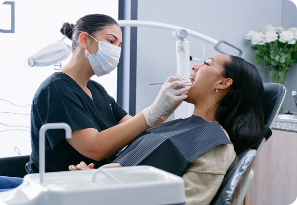 A female dentist working on a woman's teeth