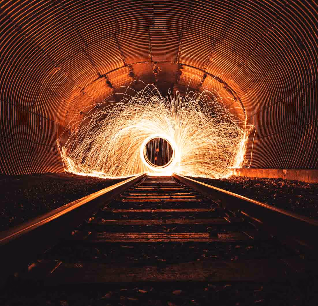 Colour photo of train tracks leading to a circle created by sparks representing the transparency of investment reporting.