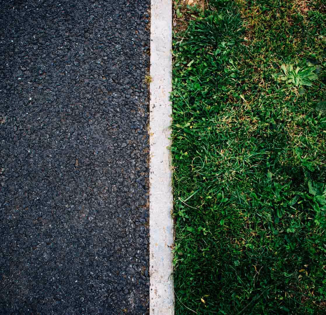 A Photo of a lawn and tar road separated by a concrete line representing the effective diversification applied to the InvestSense portfolios.