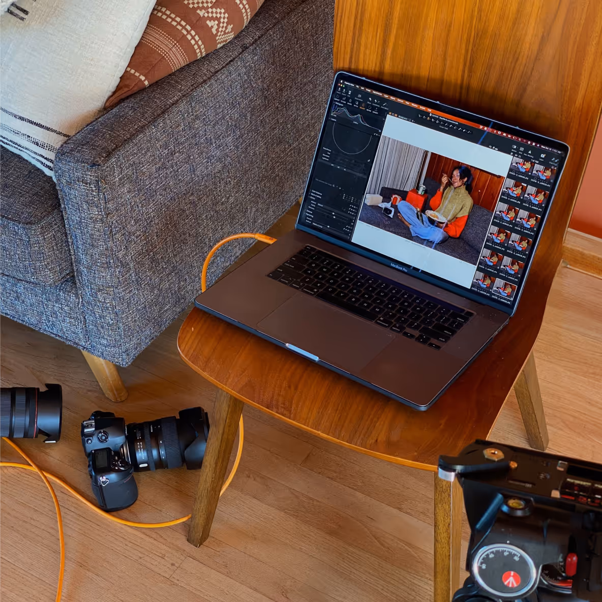 A tethered photography setup showing a MacBook Pro and professional camera equipment. Wave's Tags feature allows photographers to label and track specific project expenses like gear rentals and studio costs for better financial organization.