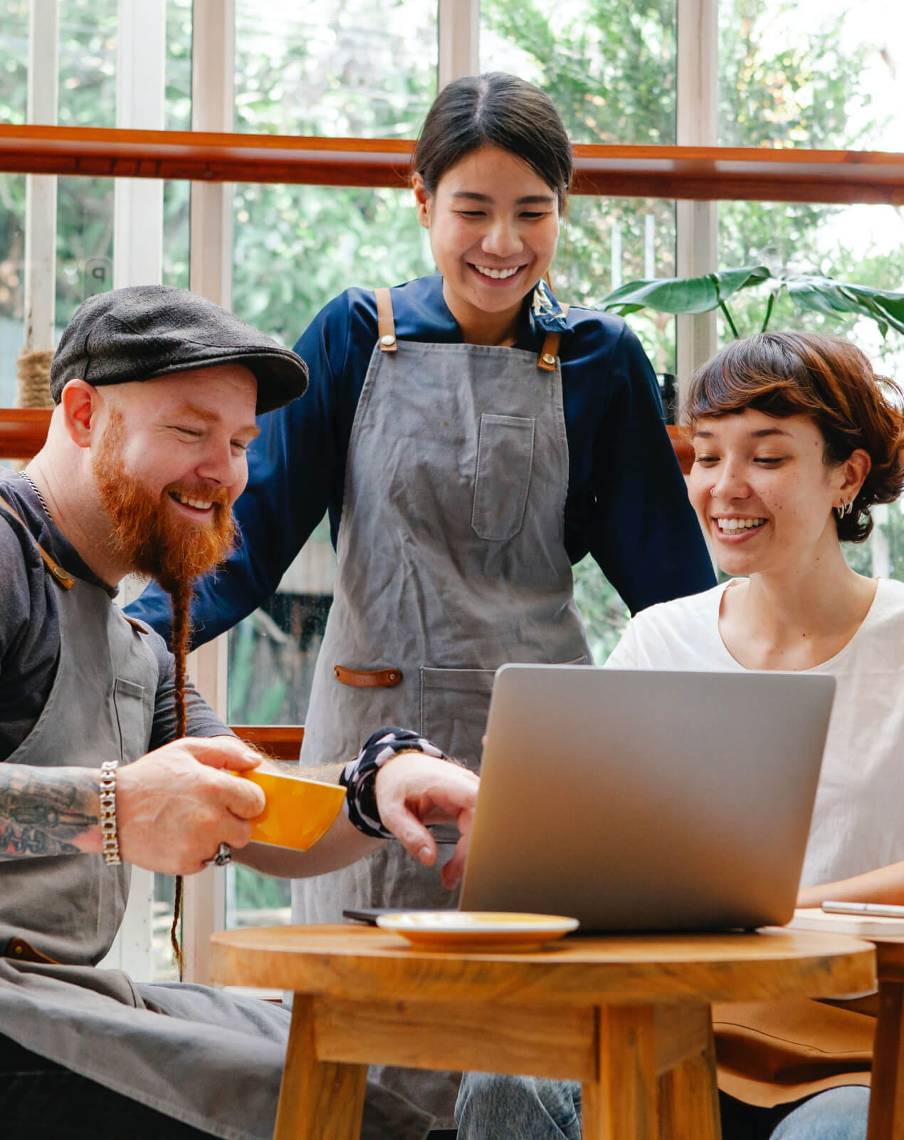 Three person at a cafe with a computer