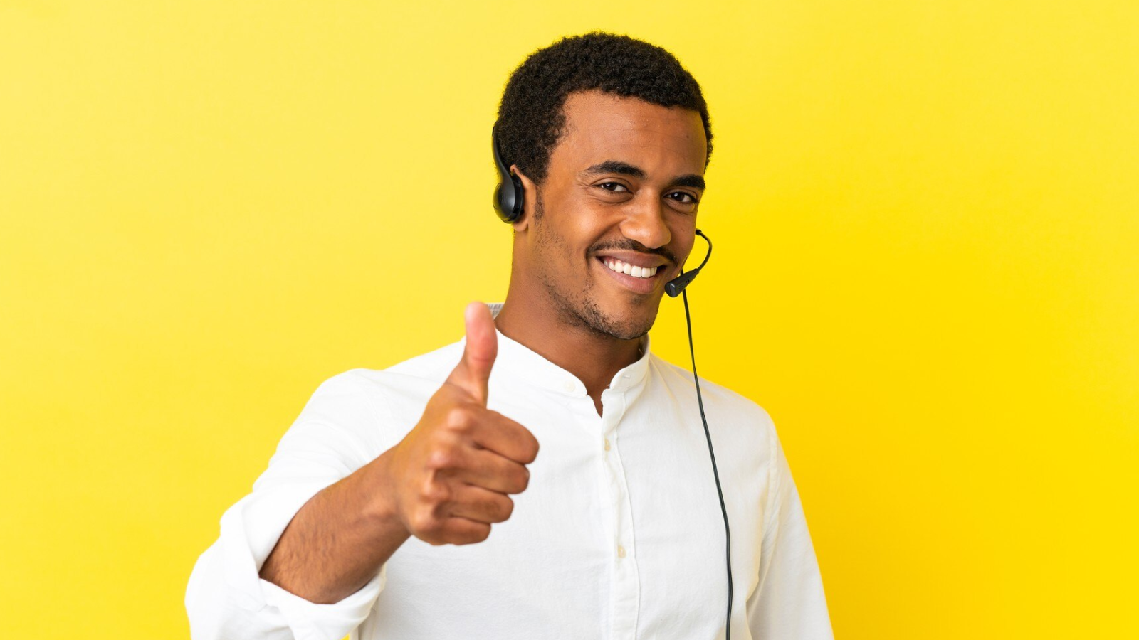 Smiling support agent with headset gives thumbs up, illustrating strong call center operations and a seamless customer experience.