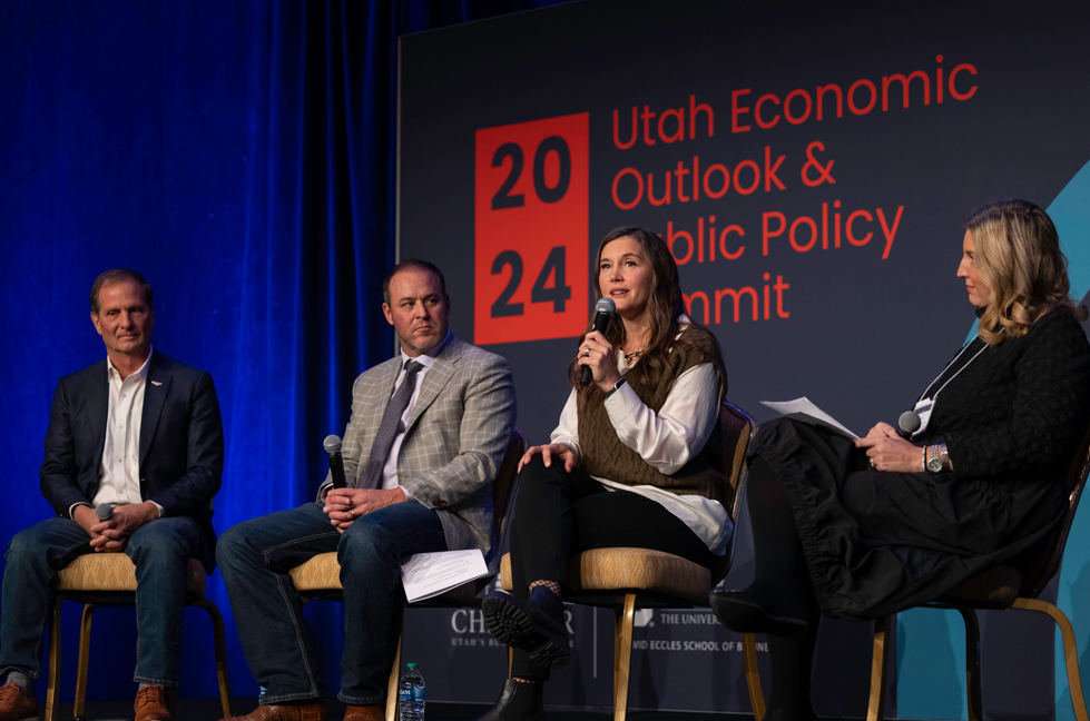 Four people sitting on a stage at he Utah Economic Outlook & Public Policy Summit