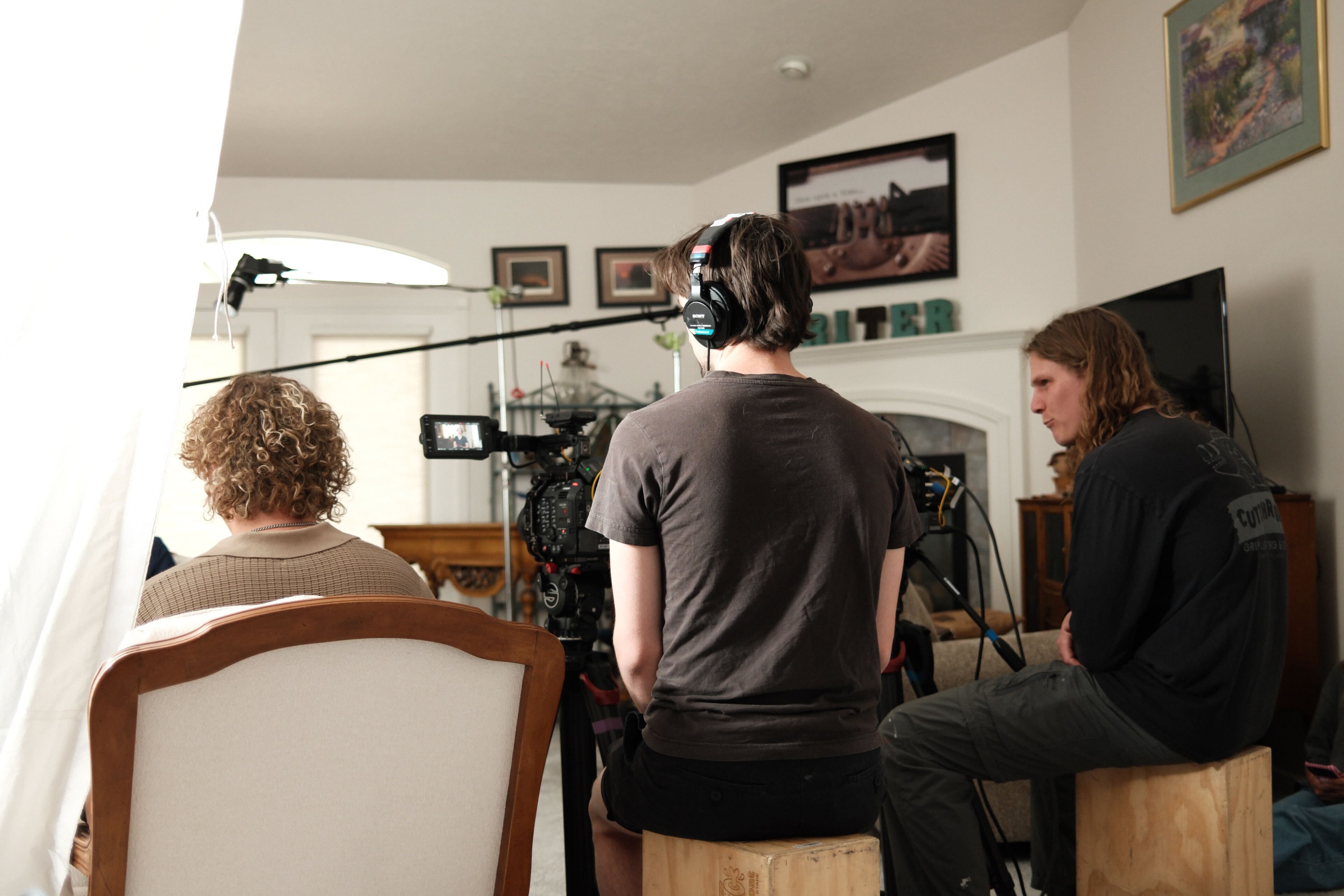 Three guys sitting behind the scenes on a film set