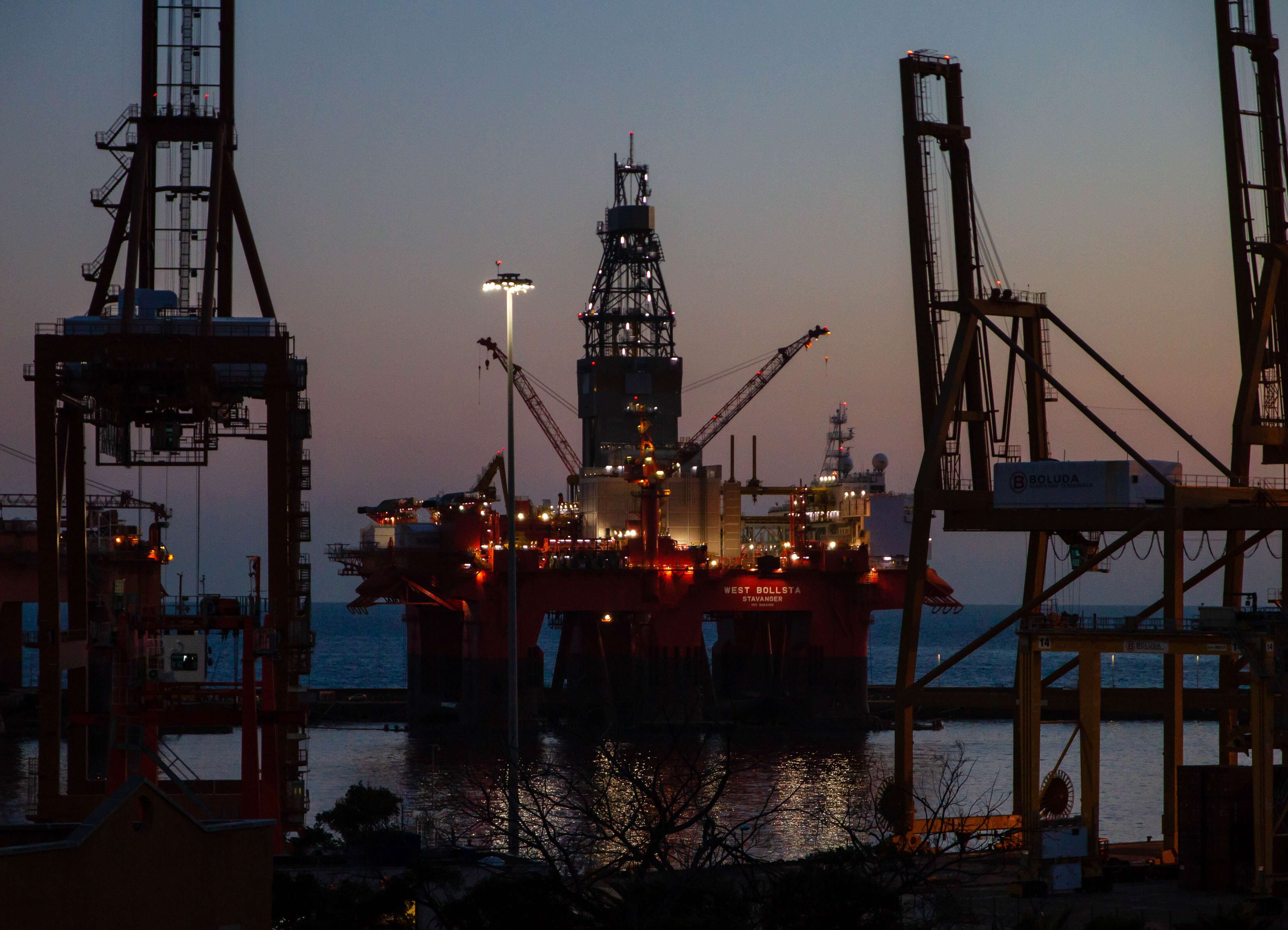 several cranes above the buildings in oil field 