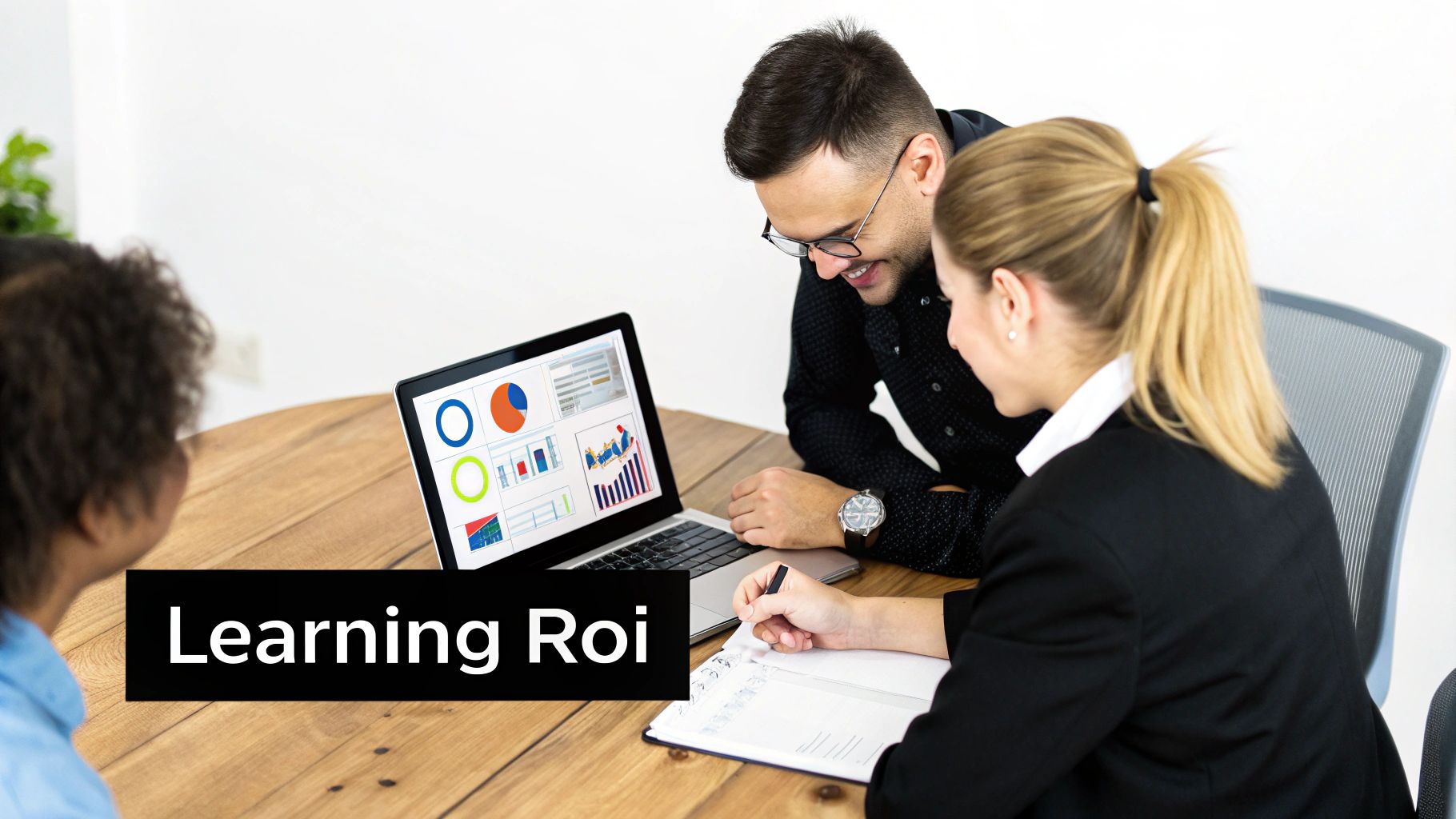 Professionals analyze learning ROI data on a laptop displaying charts and graphs at a wooden table.