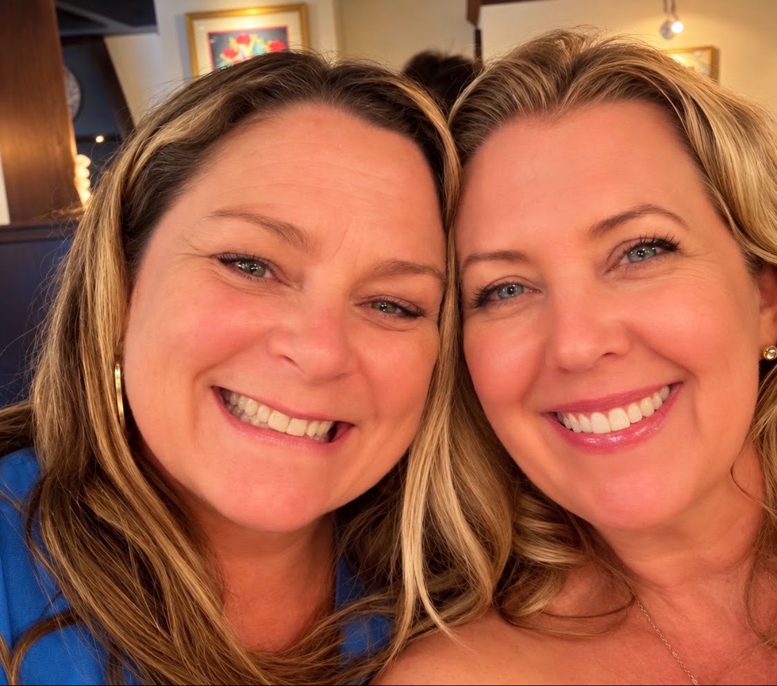 Two women take a selfie and smile at the camera