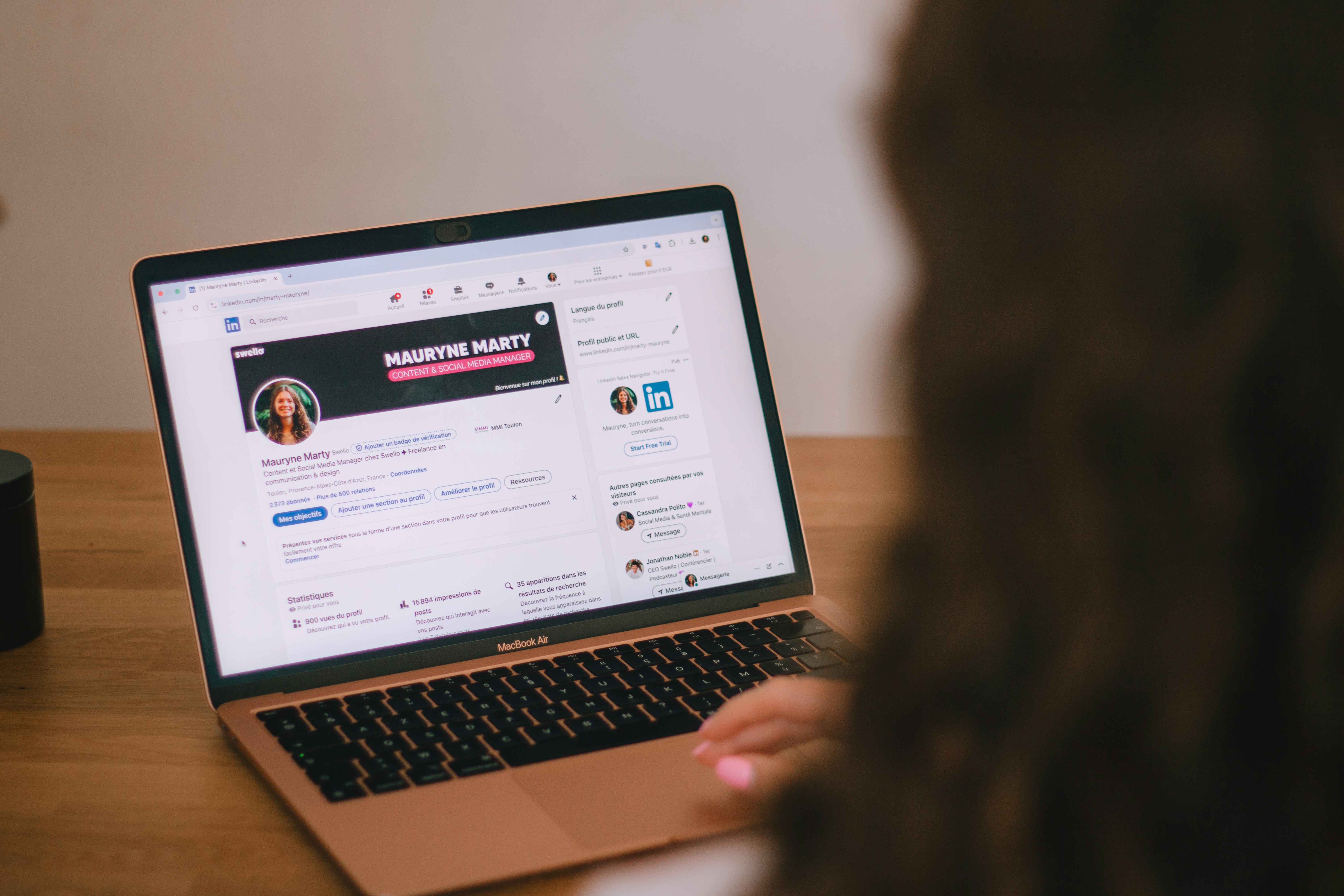 A marketer looking at LinkedIn Ads performance data on a large extended screen