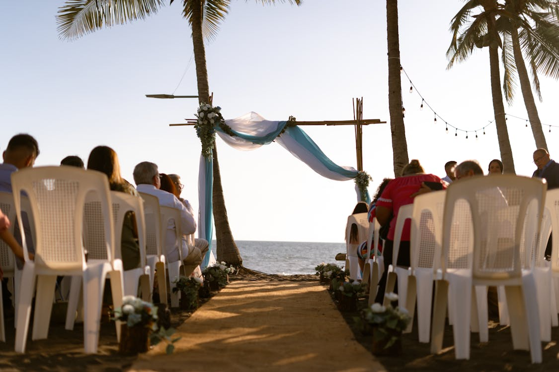 Destination civil marriage setup on a tropical beach with chairs and a archway