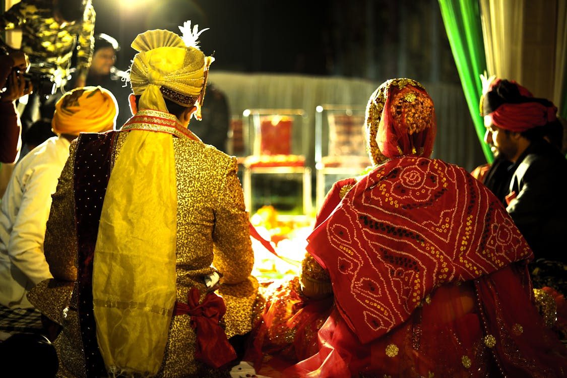 Couple seated during a traditional wedding ceremony, illustrating proper wedding etiquette for cultural rituals 