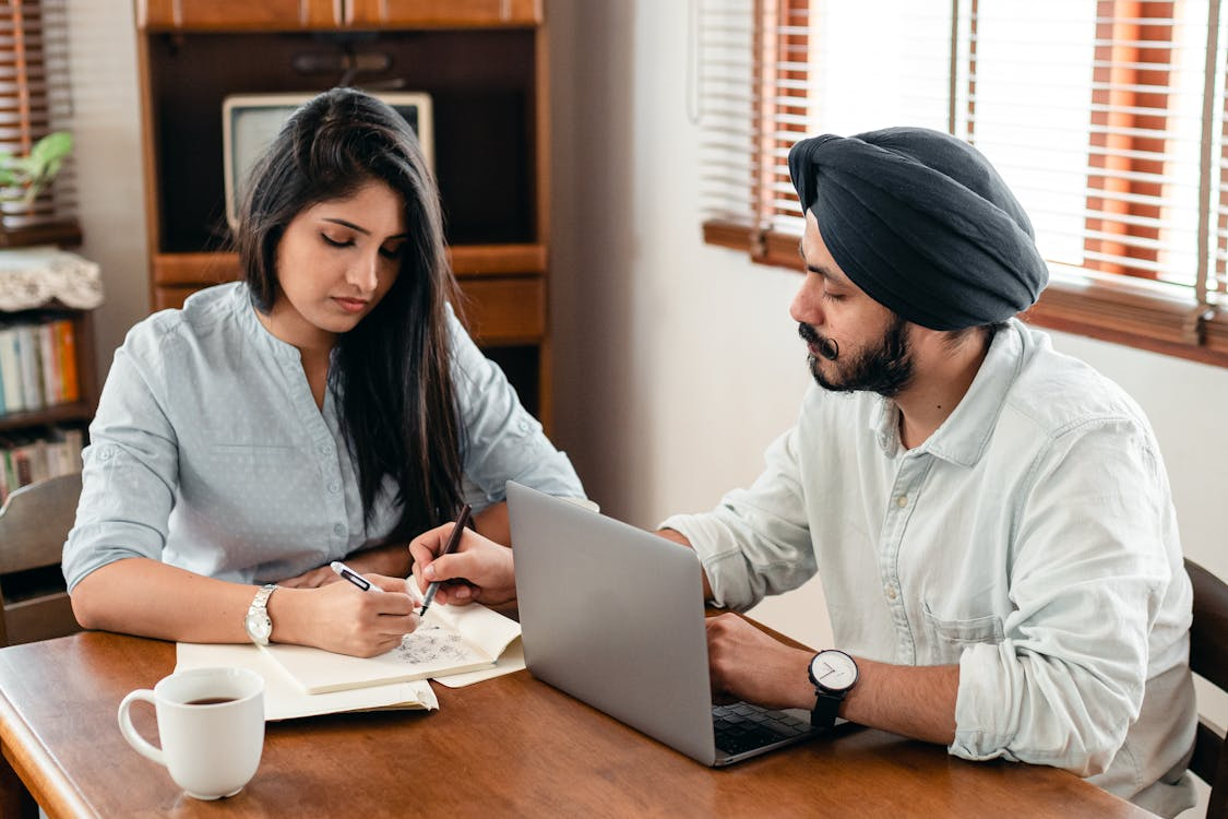 Couple reviewing paperwork together at home while preparing documents for the citizenship through marriage process.