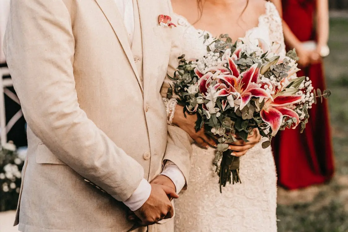  Bride holding a wedding bouquet beside her partner during a ceremony, symbolizing the benefits of getting married.