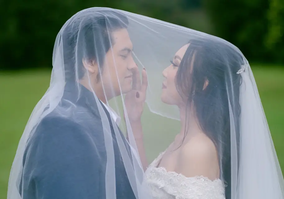 Filipino catholic wedding traditions; bride and groom under the bride’s veil.