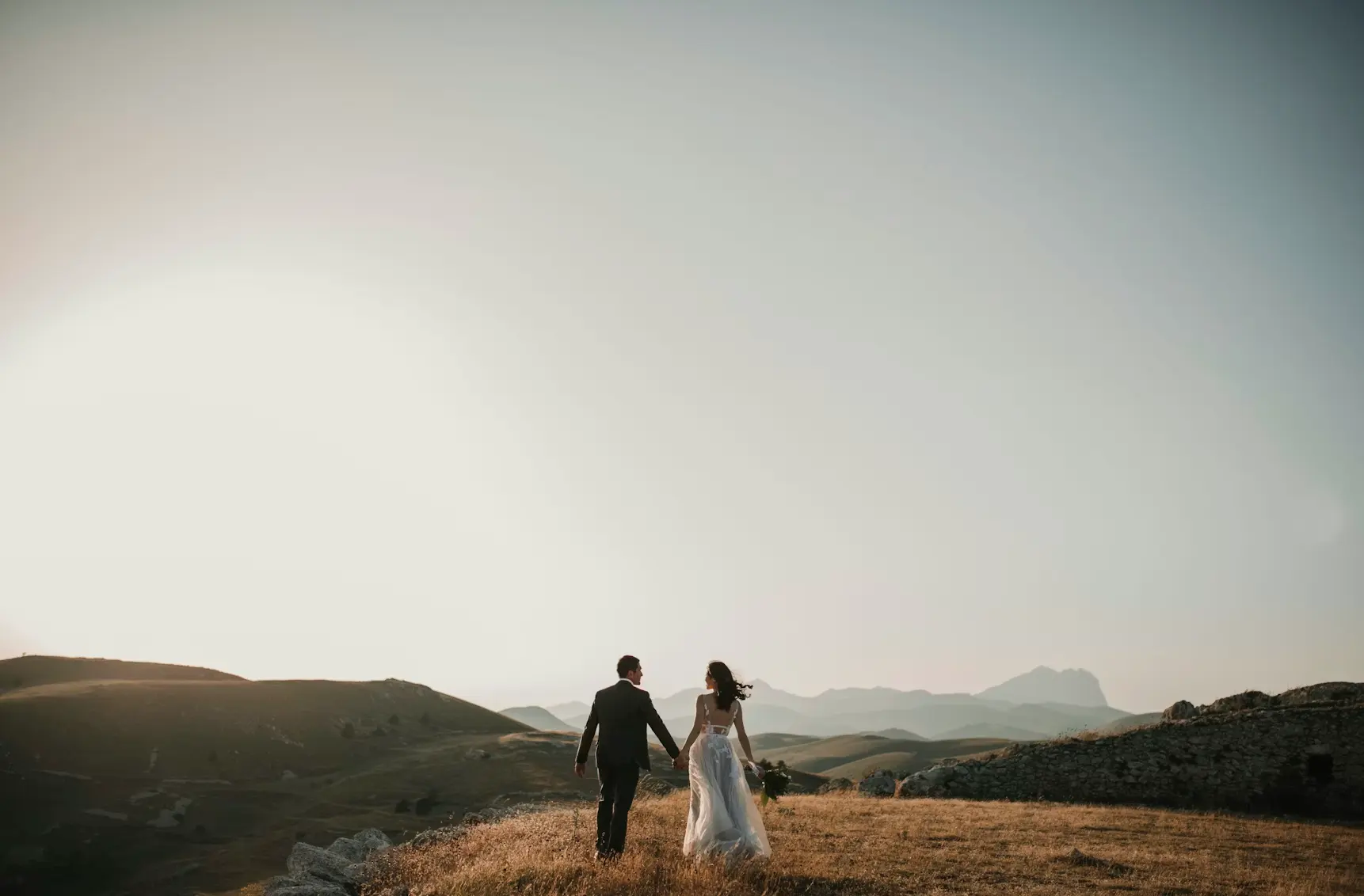 Bride and groom standing in field: legal benefits of marriage.