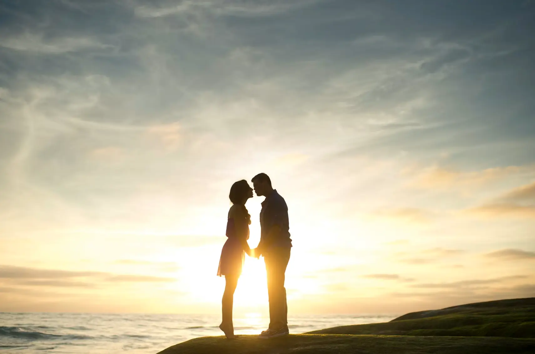 Couple posing on a mountaintop kissing: legal age for marriage in the US.