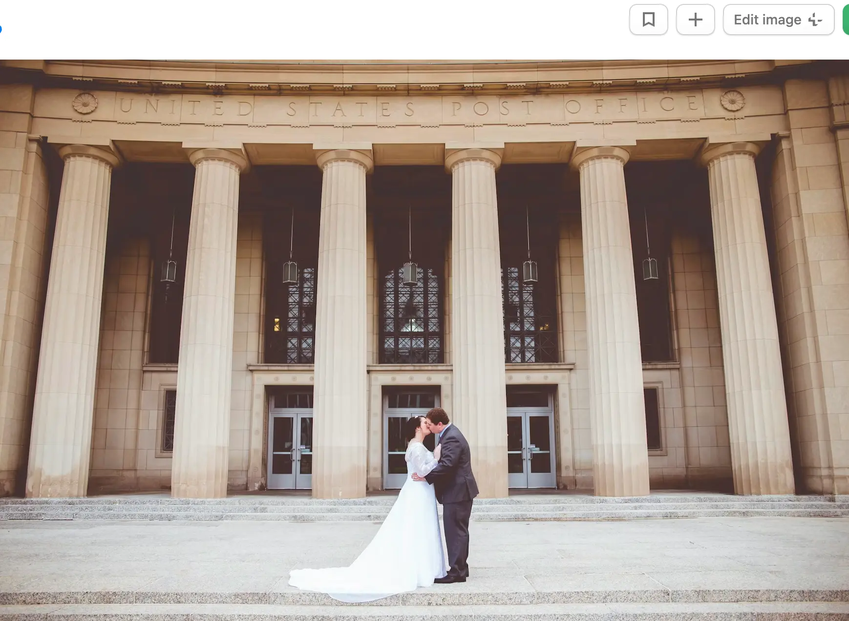 Newlywed couple kissing in front of the US Post Office.