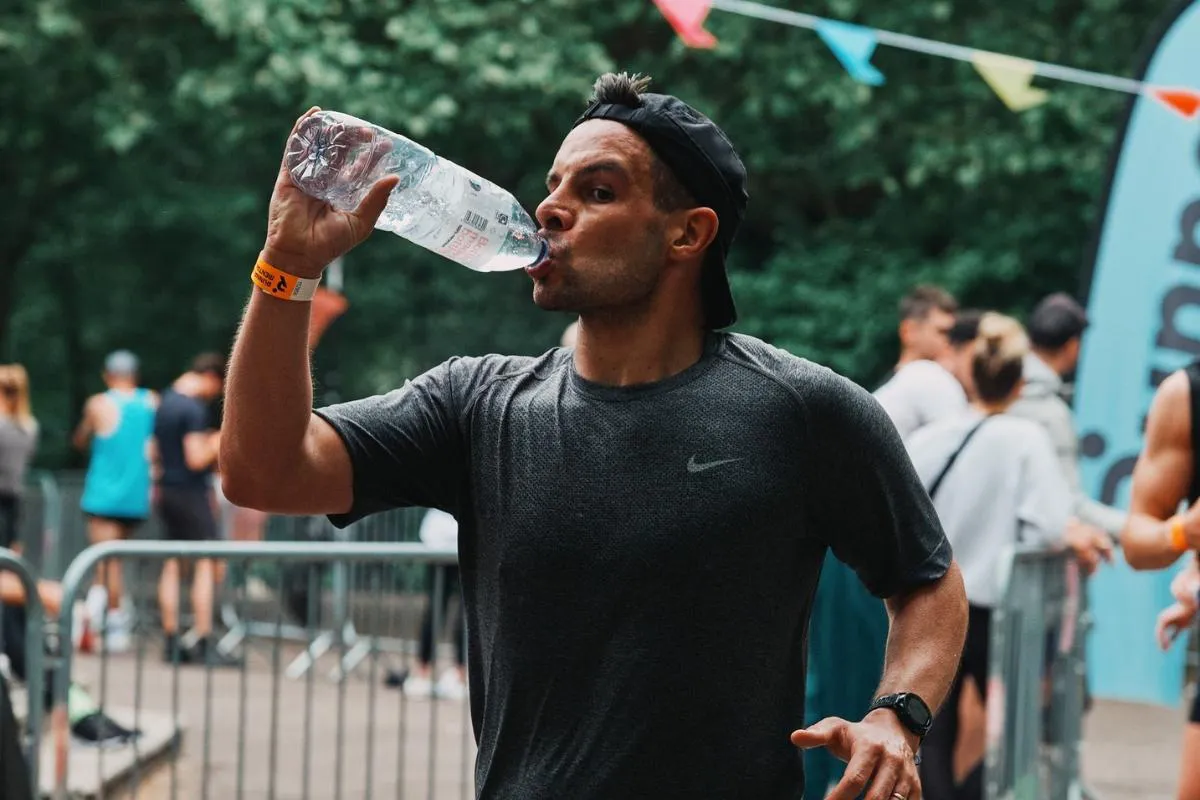 Un coureur qui boit de l'eau.