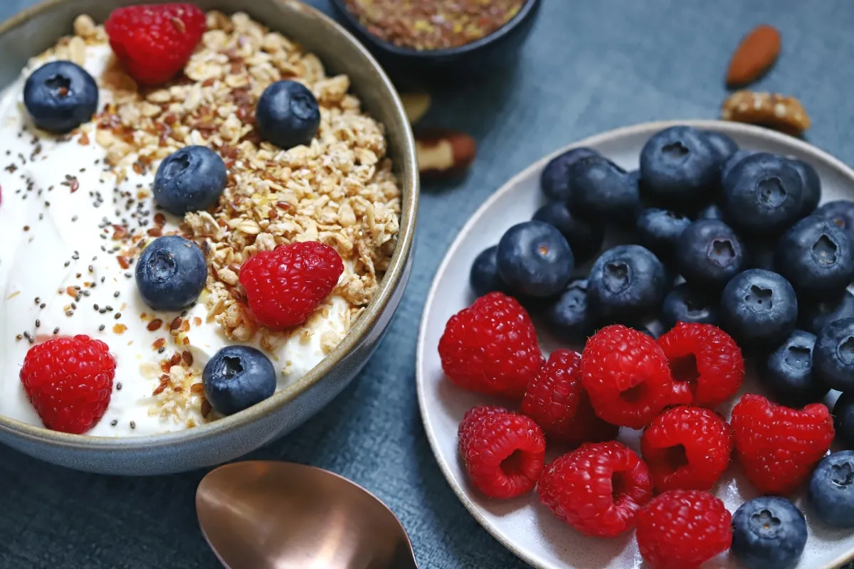 Iogurte grego com frutas vermelhas e granola.