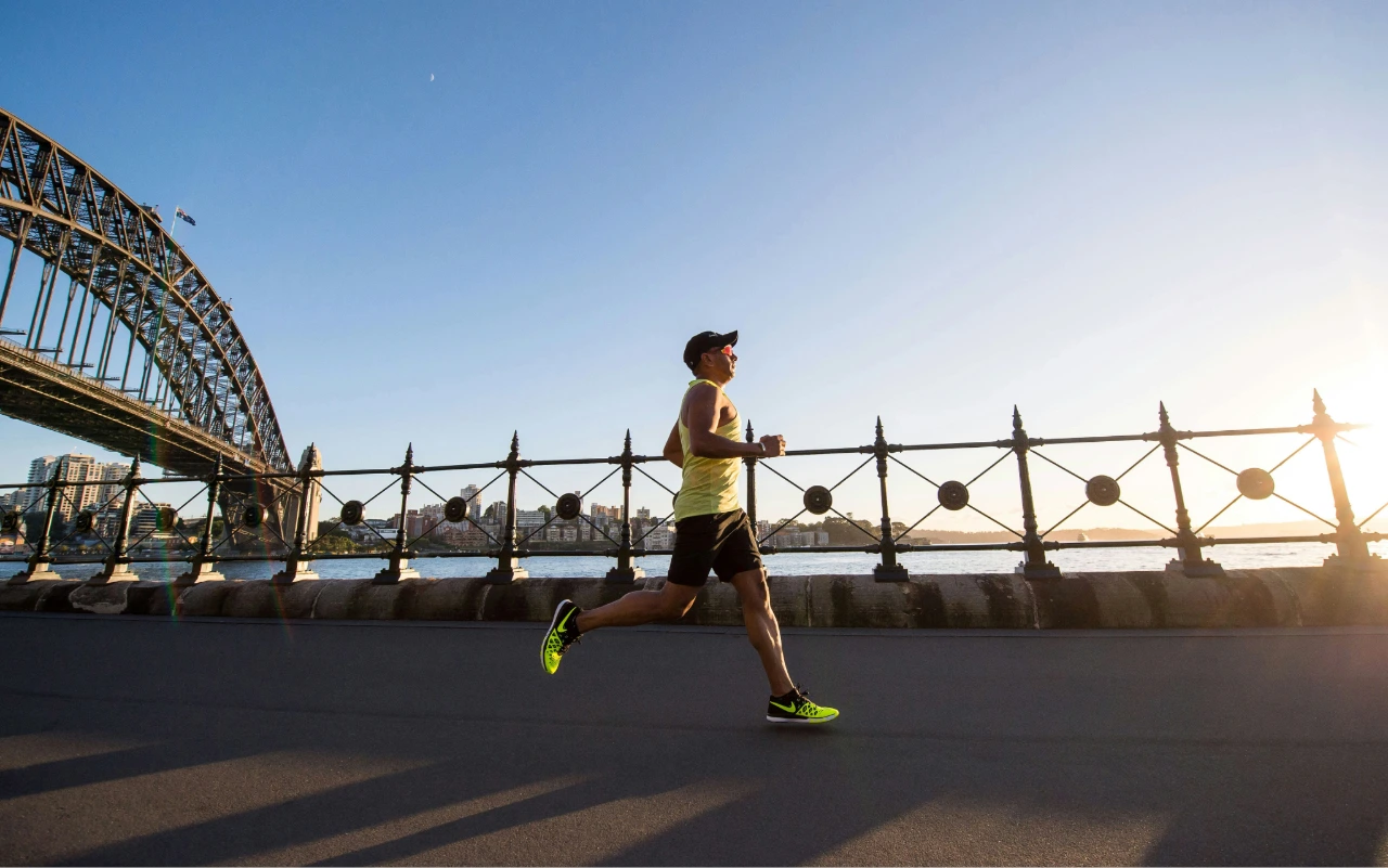 Man running with a cap on.