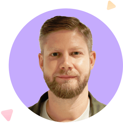 Close-up portrait of a light-skinned man with a beard and short hair, against a purple circular background with small orange and pink shapes.