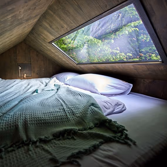 Ubytování v posedu Two Fingers - postel s výhledem ze střešního okna