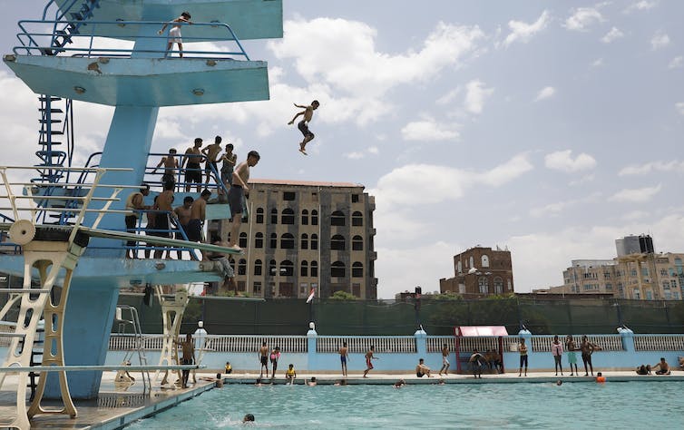 person falls from high platform toward pool'