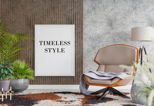 interiors with a sofa chair. There is grey color wall covering with a frame hanging in the middle of the wall stating- Timeless style