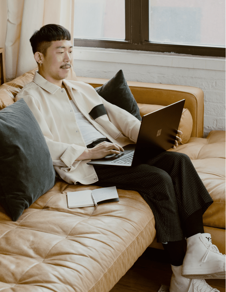 Image of a man on a couch with a laptop