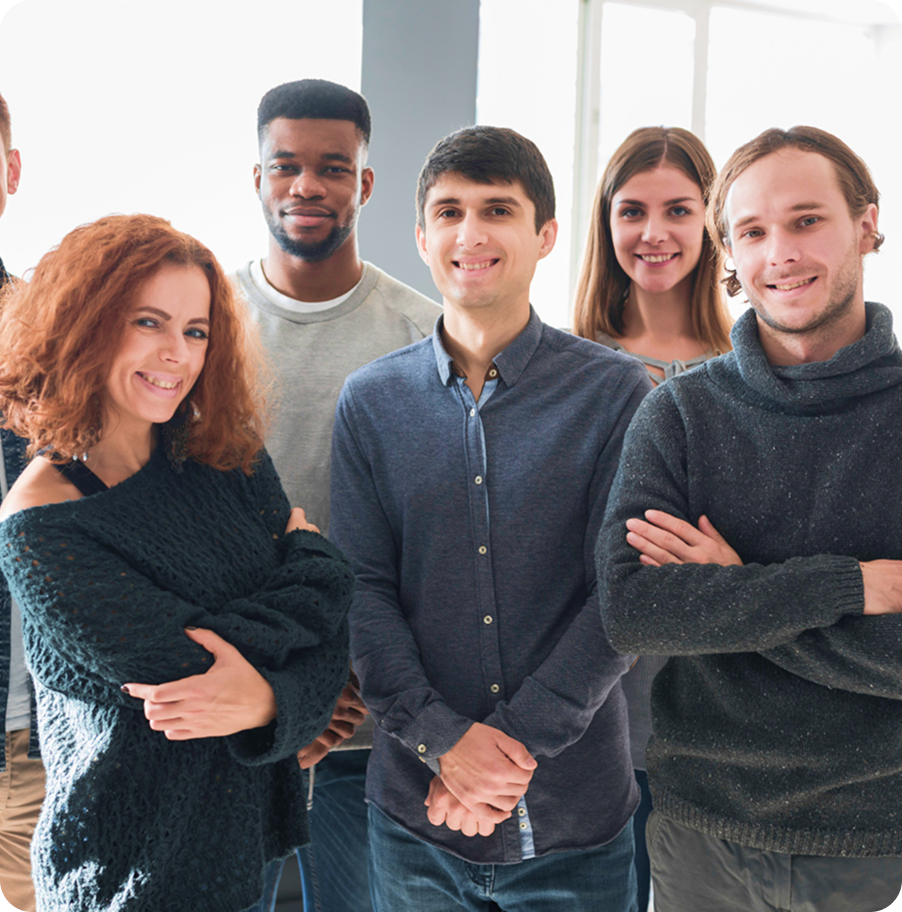 Group of smiling young professionals standing together in a bright office