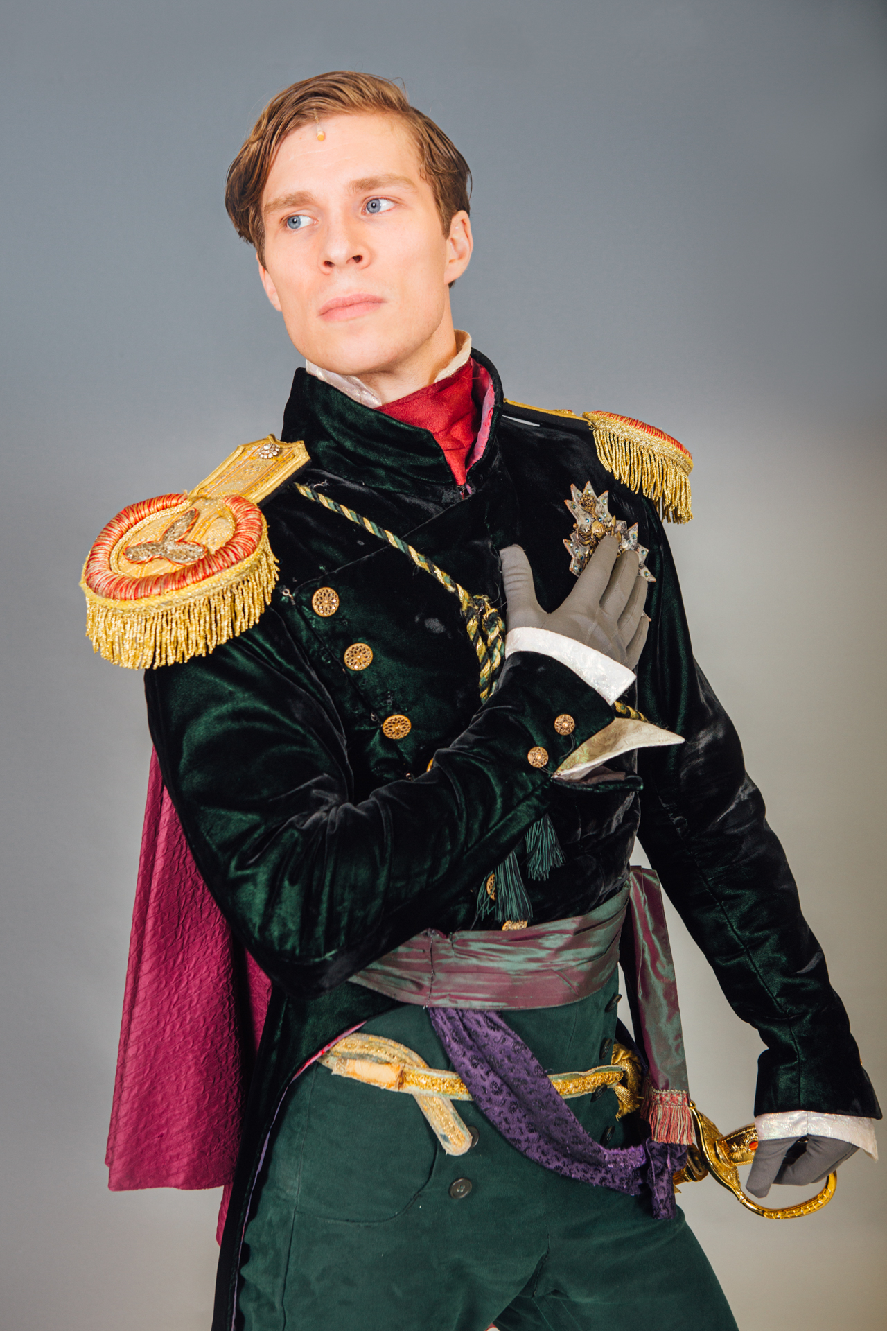 An adult in admiral's clothing poses for a portrait backstage