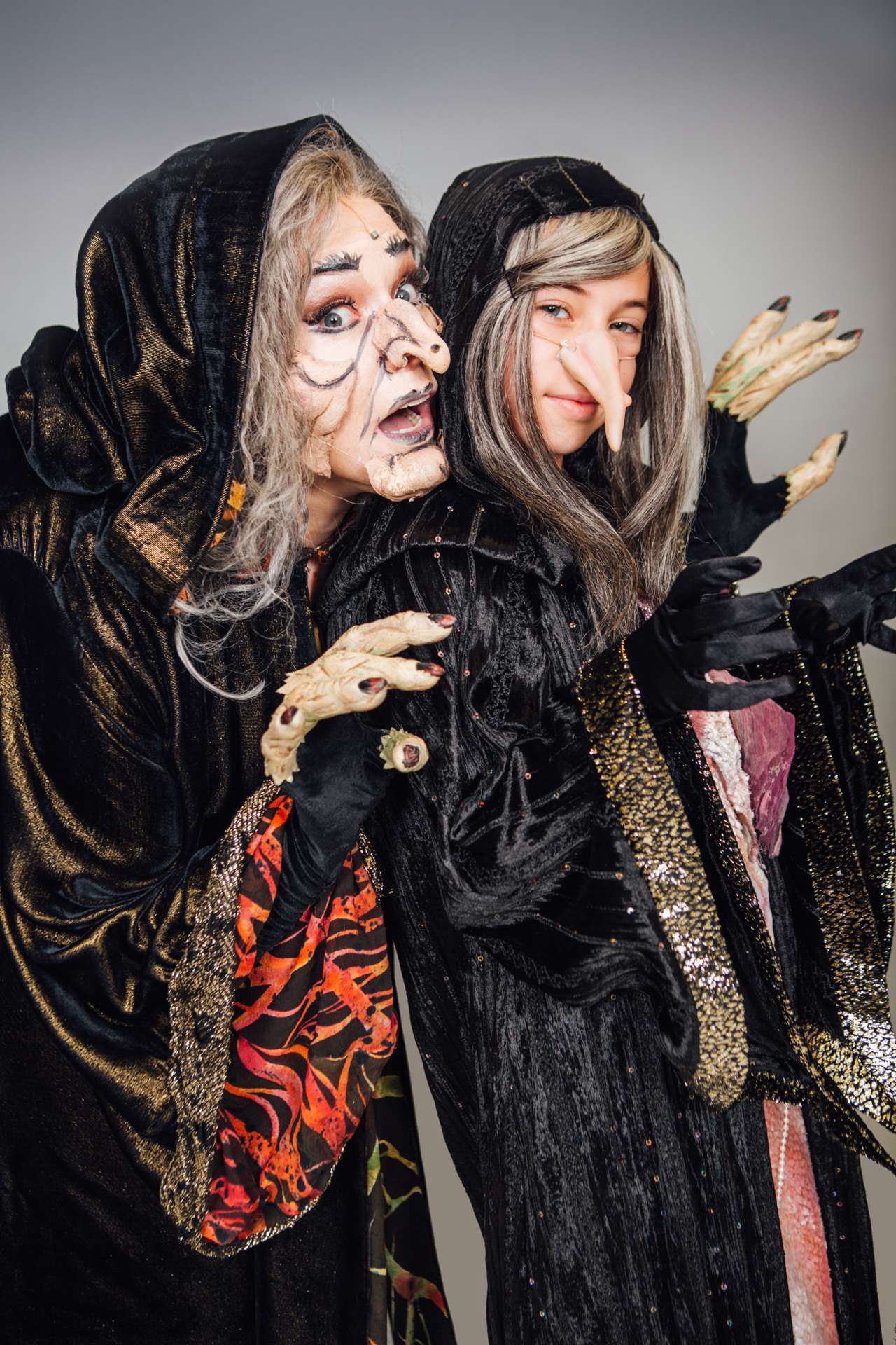 Adult witch and child witch pose for a backstage portrait