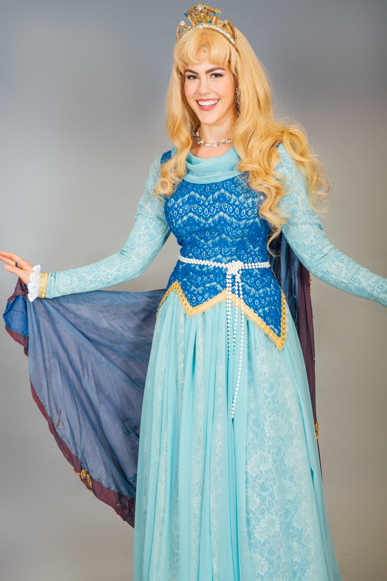 A Cinderella looking character dressed in blue with blonde hair poses for a portrait picture