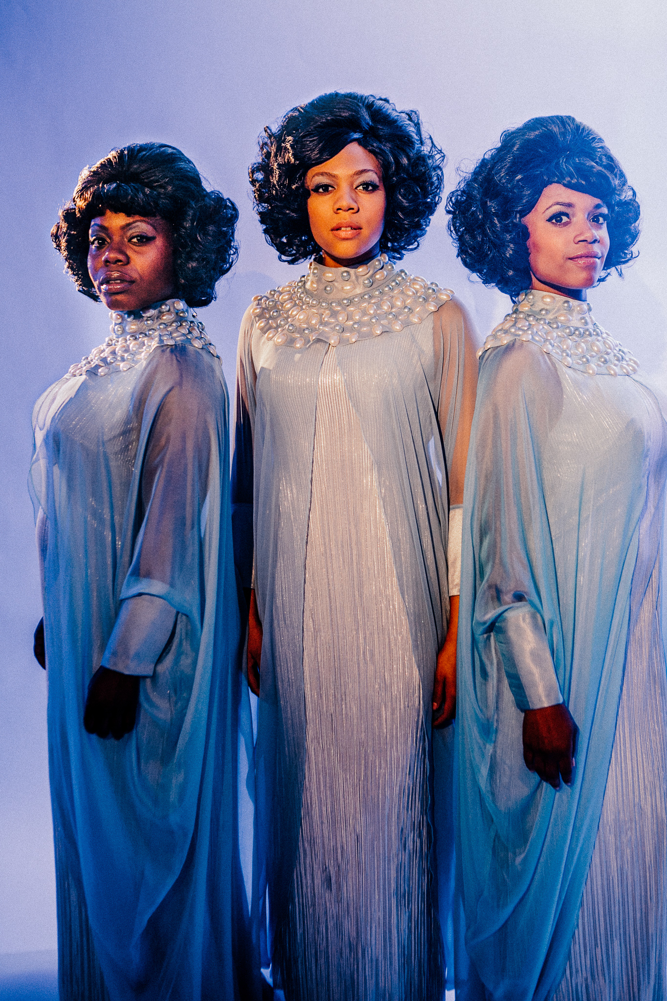 Image of actresses dressed up as the Dream Girls in a portrait orientation with blue lighting