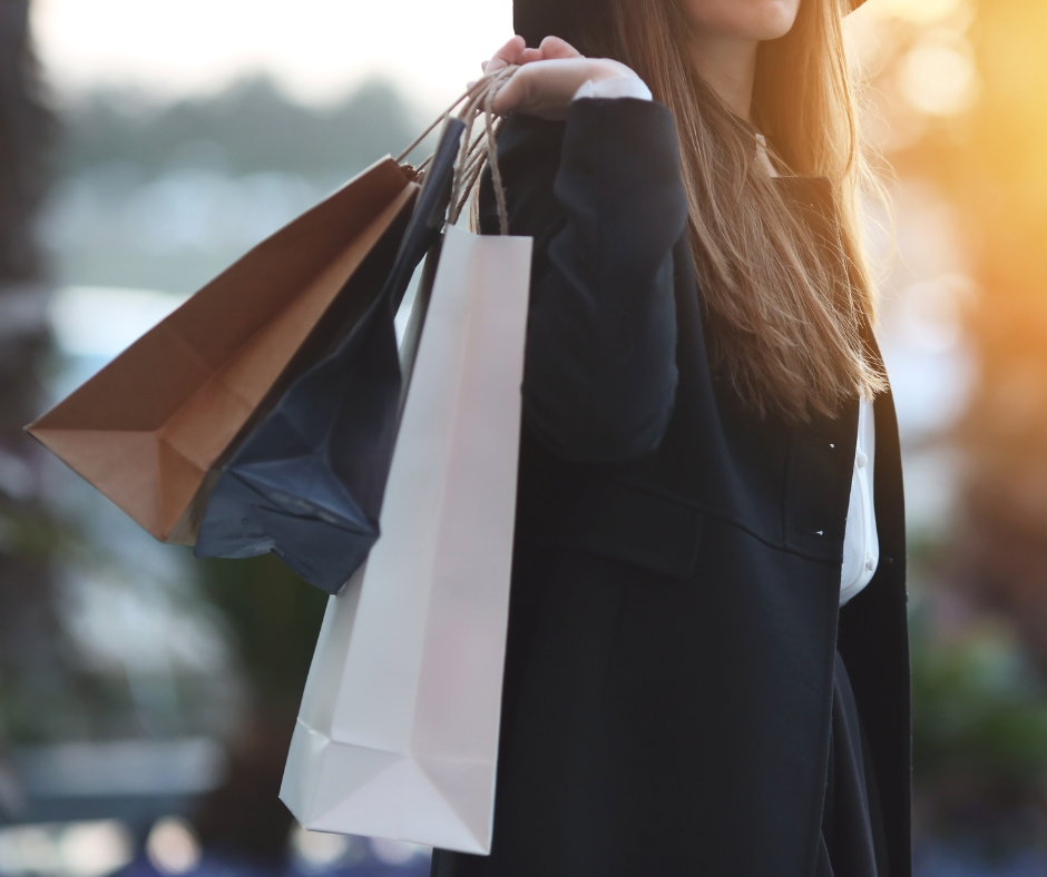 A woman holding shopping bags over her shoulder
