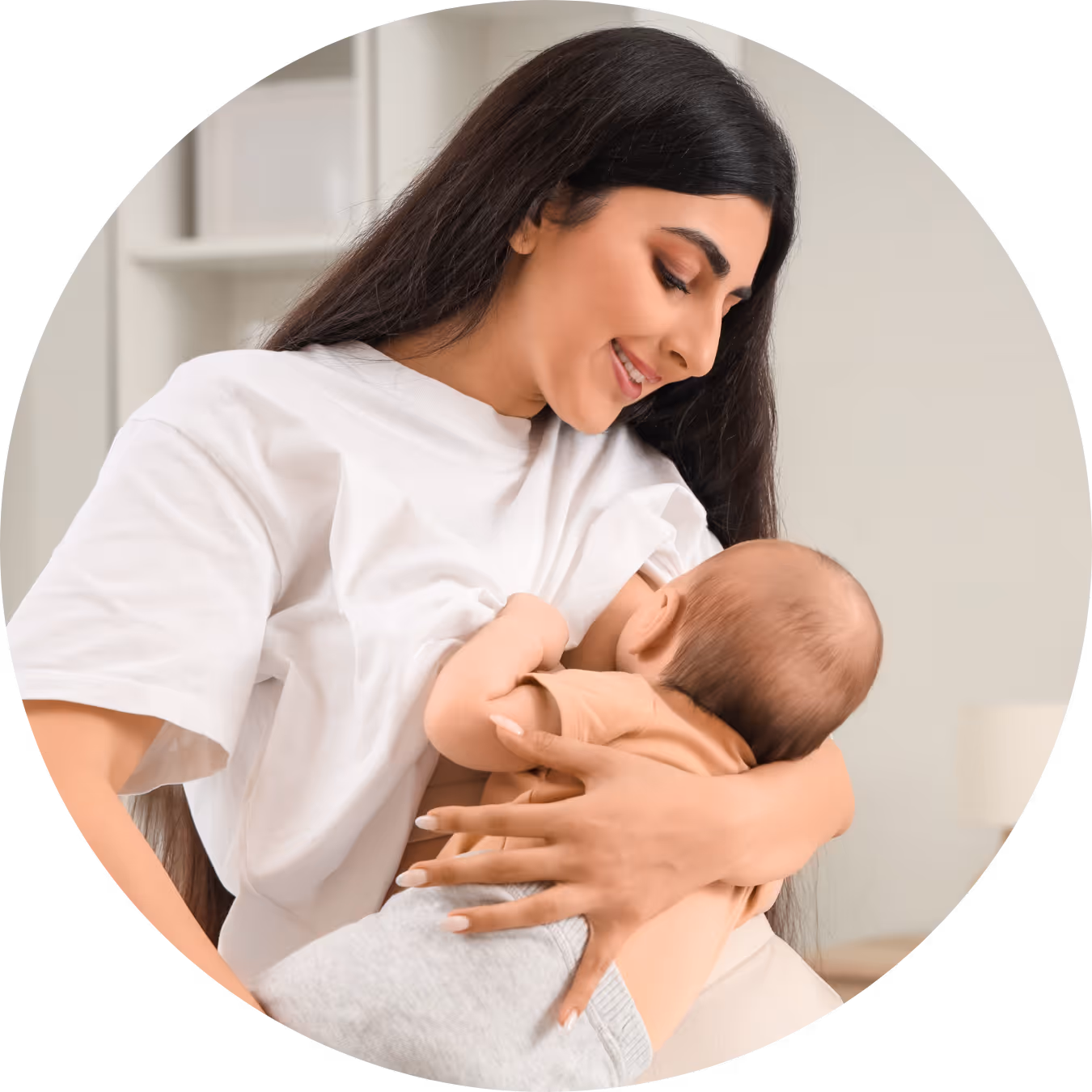 Mother breastfeeding her baby with a gentle smile in a bright room.