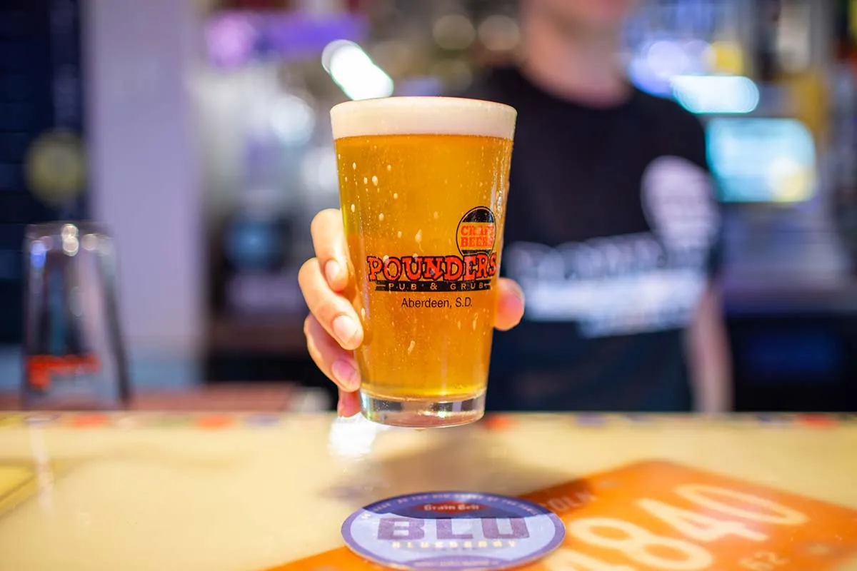 server handing beer to bar
