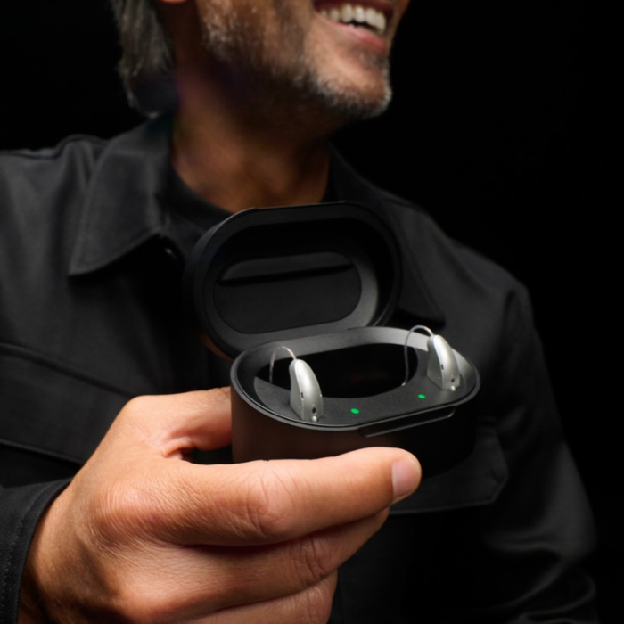 Rechargeable Starkey Omega AI hearing aids resting in a portable charging case, highlighting convenient all-day battery life and easy charging for daily use.