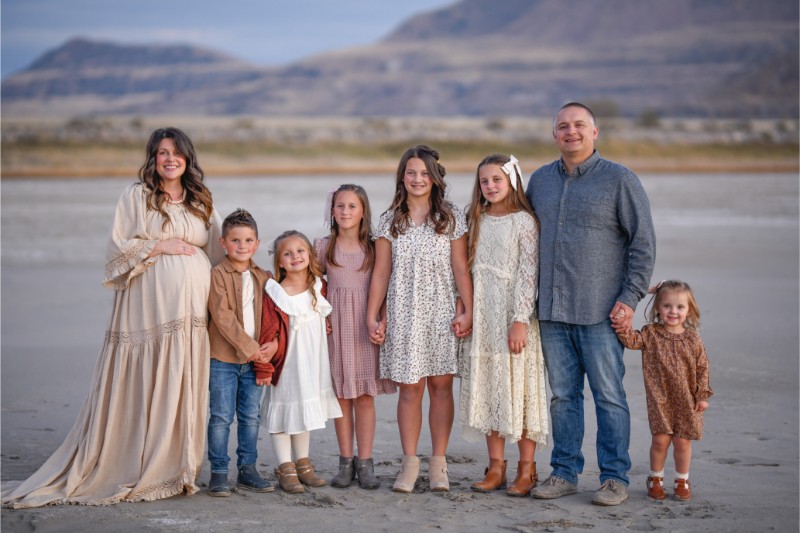a family smiles holding hands in the desert