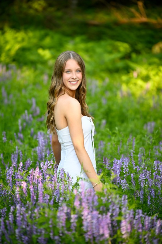 a girl smiles in a field of purple flowers