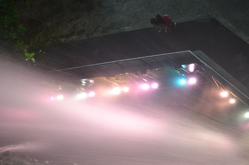manmade waterfall with 2 girls standing in front of it.