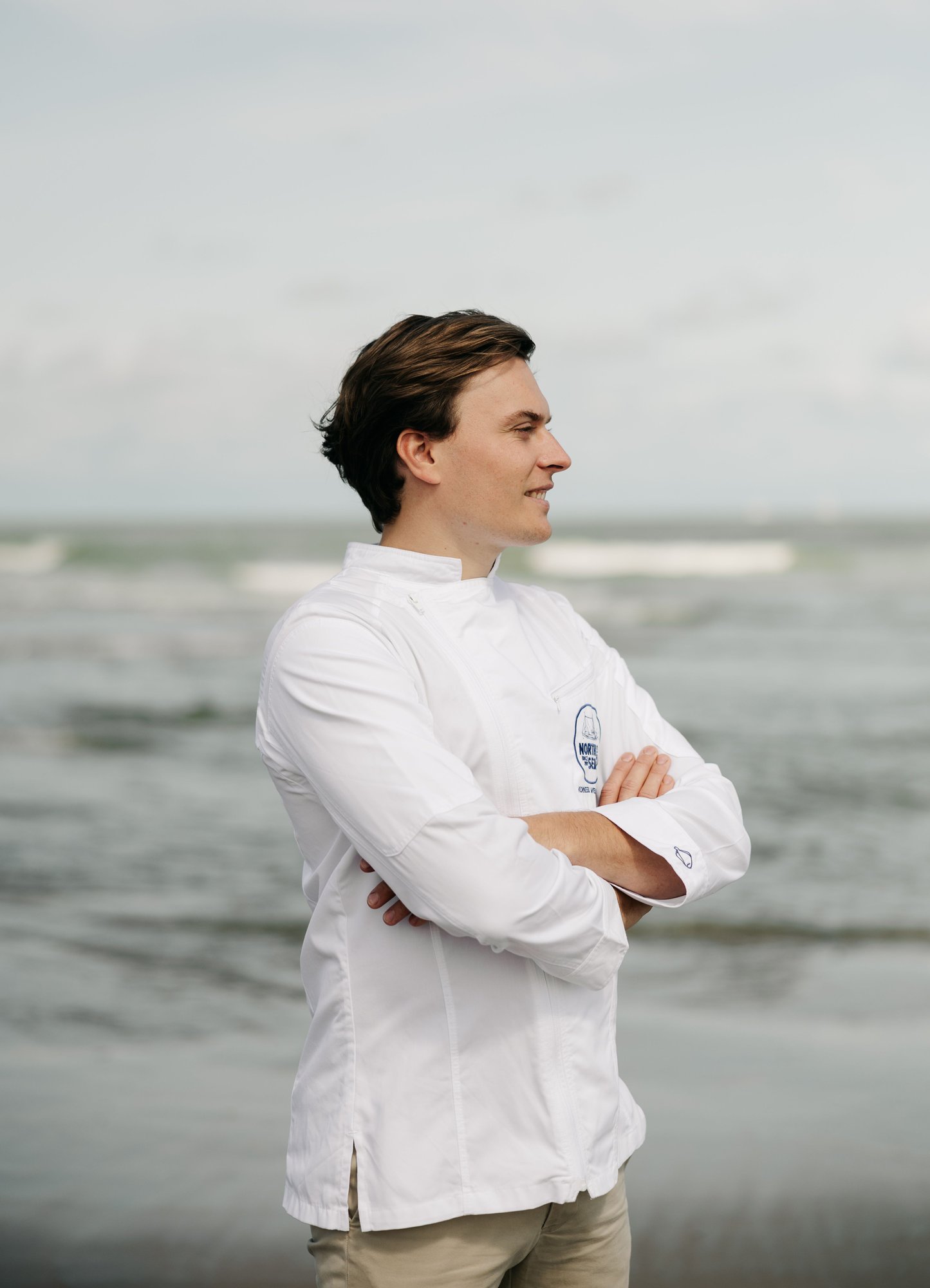 Photo couleur du chef Korneel Verhulst en veste de cuisine blanche NorthSeaChefs au bord de la mer