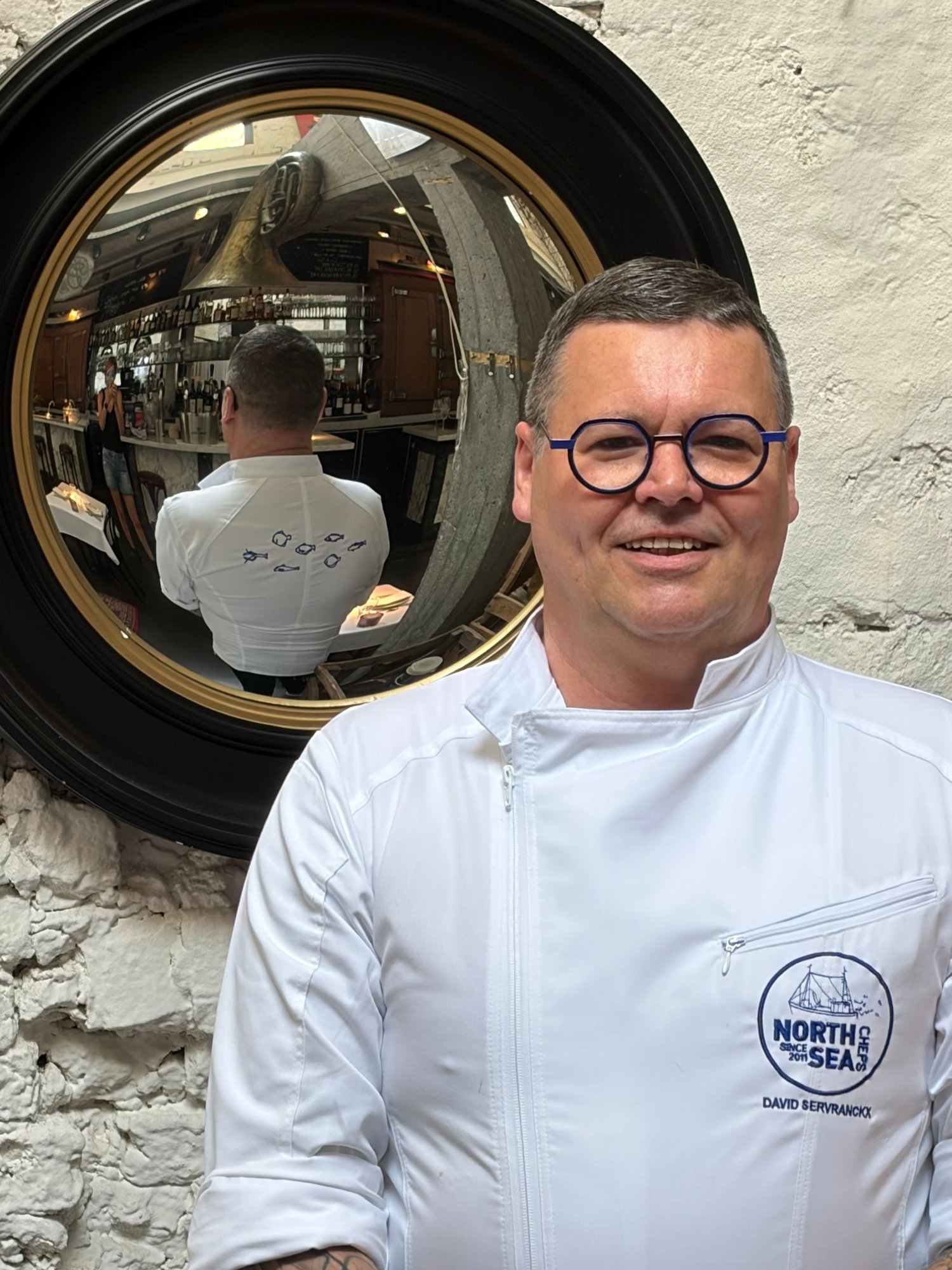 Photo couleur du chef David Servranckx en veste de cuisine blanche NorthSeaChefs, avec lunettes