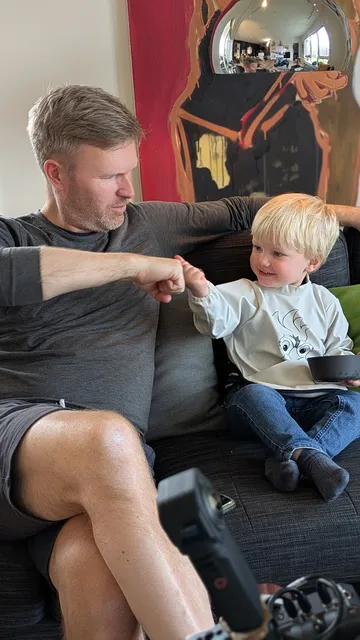 Behind the scenes bilde av fotograf og skuespiller, 2 år, som gir hverandre en fist bump i en pause fra en reklamefilminnspilling for 24Nettbutikk