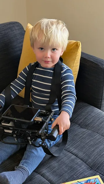 Liten skuespiller, gutt 2 år,  holder regi-monitor i en pause fra reklamefilminnspilling for 24Nettbutikk.